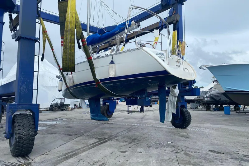 Slide: The Image of 2006 Beneteau Oceanis Clipper 323 sailboat lifted in a marina for maintenance. - 2