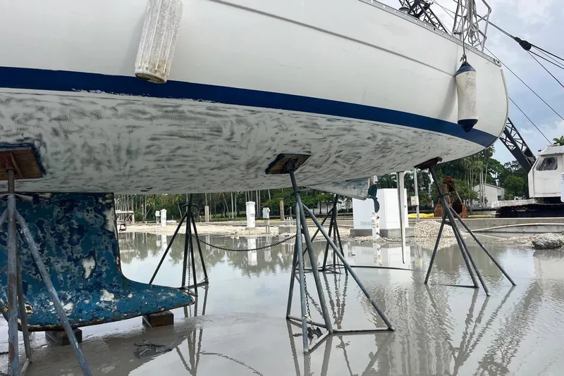 Slide: The Image of 2006 Beneteau Oceanis Clipper 323 sailboat on stands, undergoing maintenance in a marina. - 20