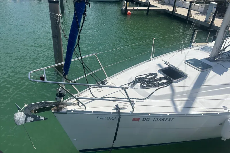 Slide: The Image of 2006 Beneteau Oceanis Clipper 323 sailboat docked in marina, featuring sleek design and anchor. - 23