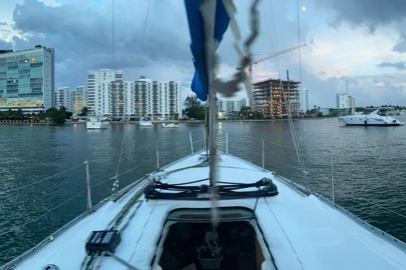 Slide: The Image of Sailing on a 2006 Beneteau Oceanis Clipper 323 near urban waterfront buildings at dusk. - 29