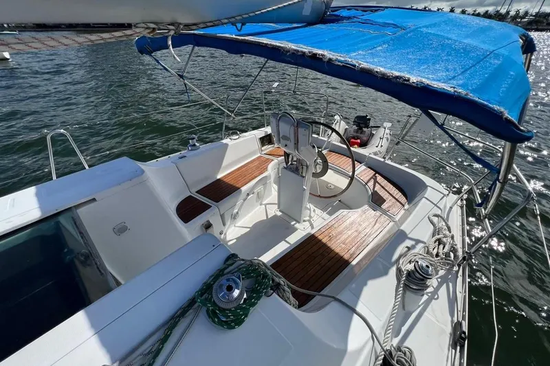 Slide: The Image of 2006 Beneteau Oceanis Clipper 323 sailboat cockpit with blue canopy and wooden seating. - 30