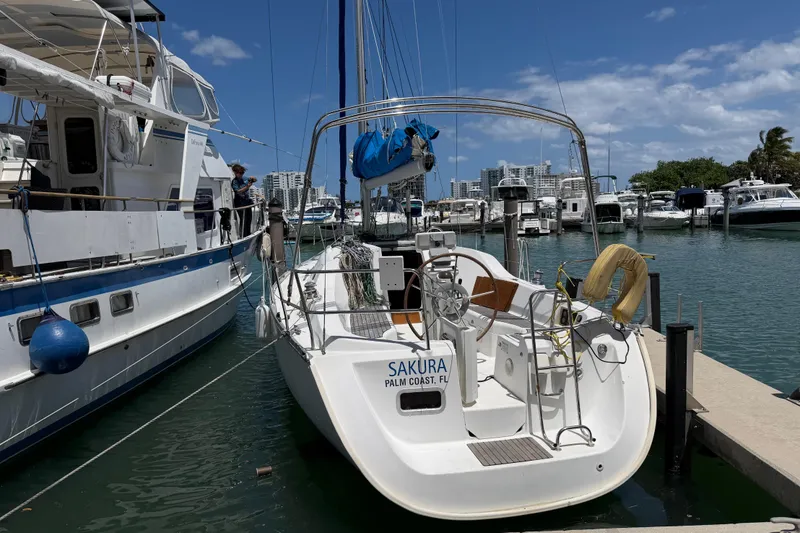 Slide: The Image of 2006 Beneteau Oceanis Clipper 323 sailboat docked in a sunny marina. - 32