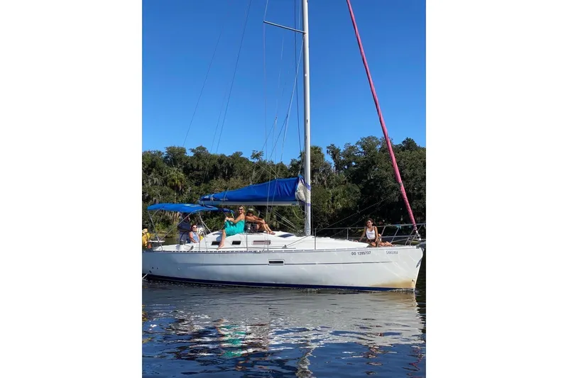 Slide: The Image of 2006 Beneteau Oceanis Clipper 323 sailboat on water with people enjoying a sunny day. - 34