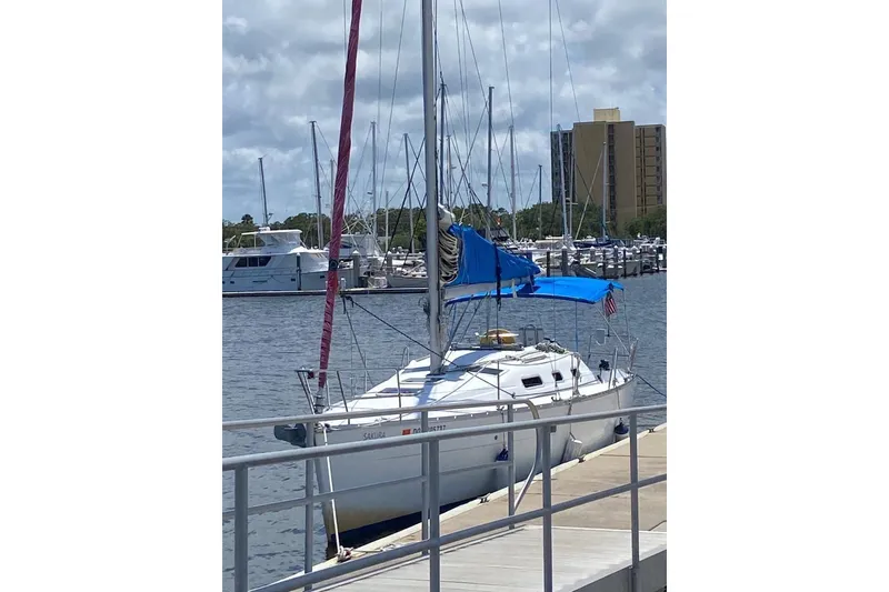 Slide: The Image of 2006 Beneteau Oceanis Clipper 323 sailboat docked at marina under cloudy sky. - 35