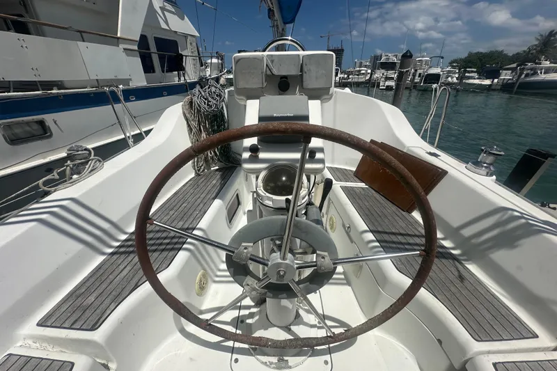 Slide: The Image of Cockpit of 2006 Beneteau Oceanis Clipper 323 sailboat with steering wheel and marina view. - 38