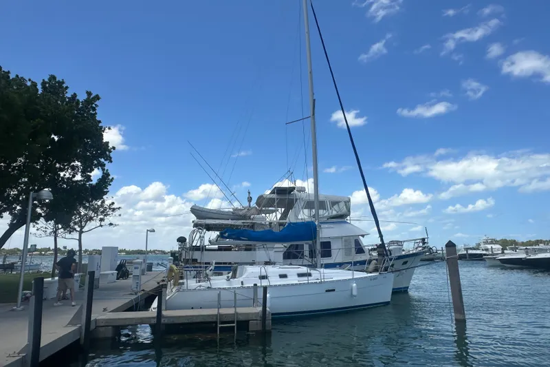 Slide: The Image of 2006 Beneteau Oceanis Clipper 323 sailboat docked at a marina under a clear blue sky. - 46