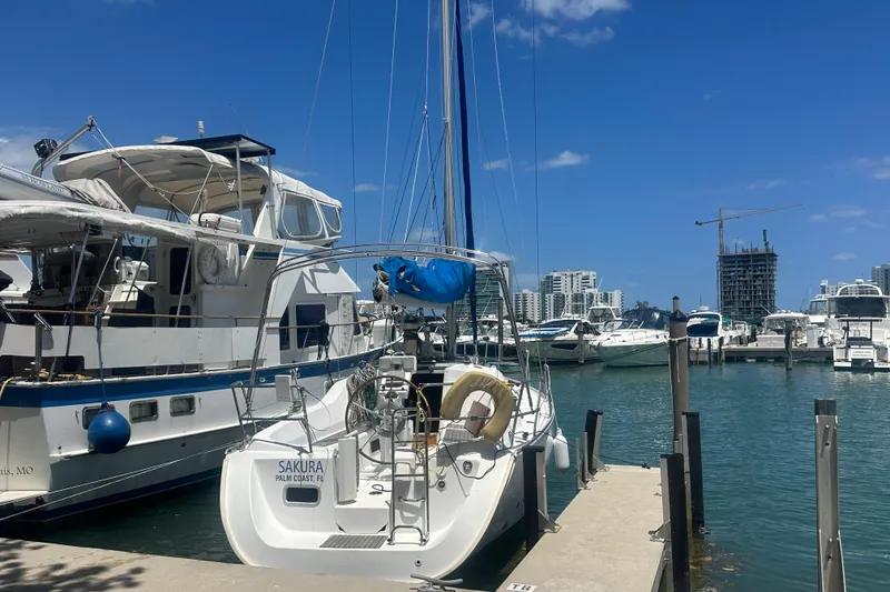 Slide: The Image of Beneteau Oceanis Clipper 323 sailboat docked at marina, clear blue sky, urban skyline. - 47