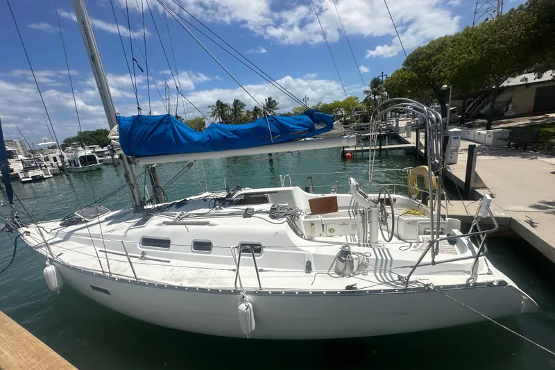 Slide: The Image of 2006 Beneteau Oceanis Clipper 323 sailboat docked in a sunny marina. - 48