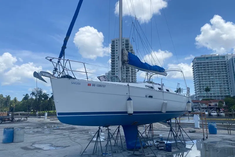 Slide: The Image of 2006 Beneteau Oceanis Clipper 323 sailboat on dry dock, with urban skyline backdrop. - 5