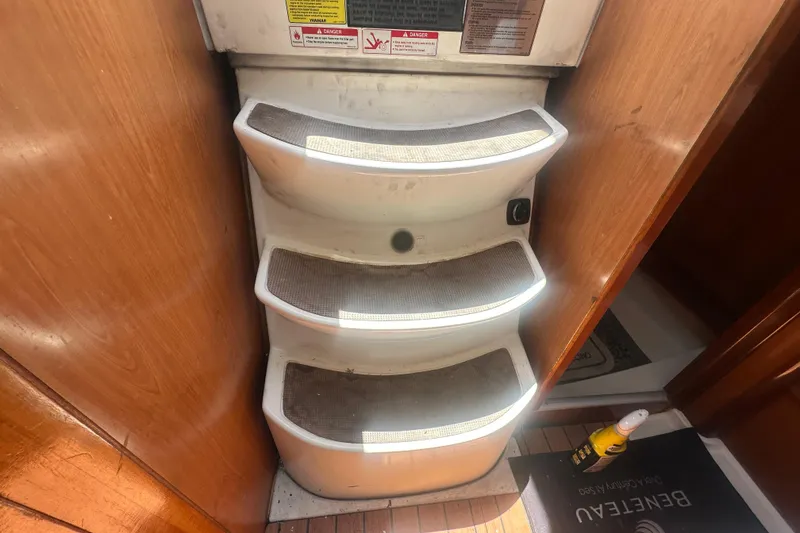 Slide: The Image of Staircase inside 2006 Beneteau Oceanis Clipper 323 yacht, featuring wooden paneling and non-slip steps. - 53