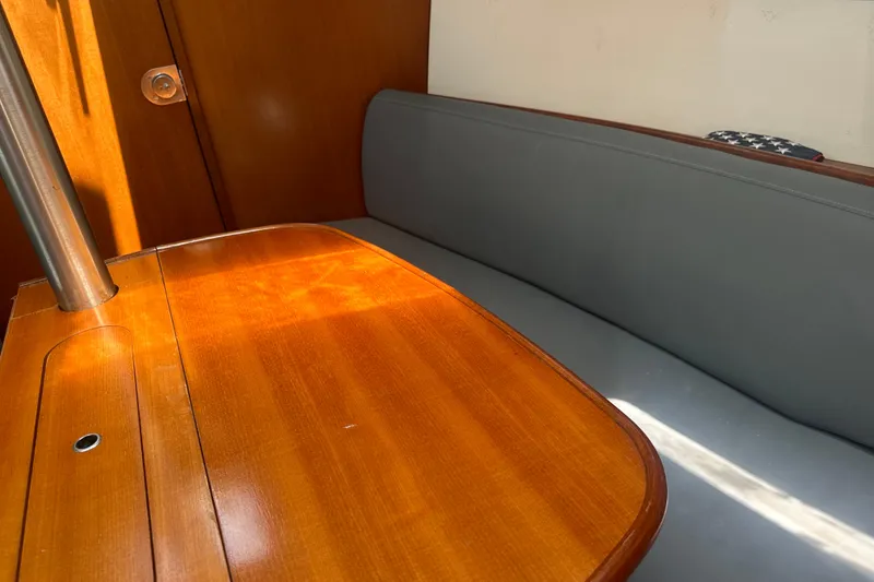 Slide: The Image of Interior of 2006 Beneteau Oceanis Clipper 323, featuring wooden table and gray seating. - 59