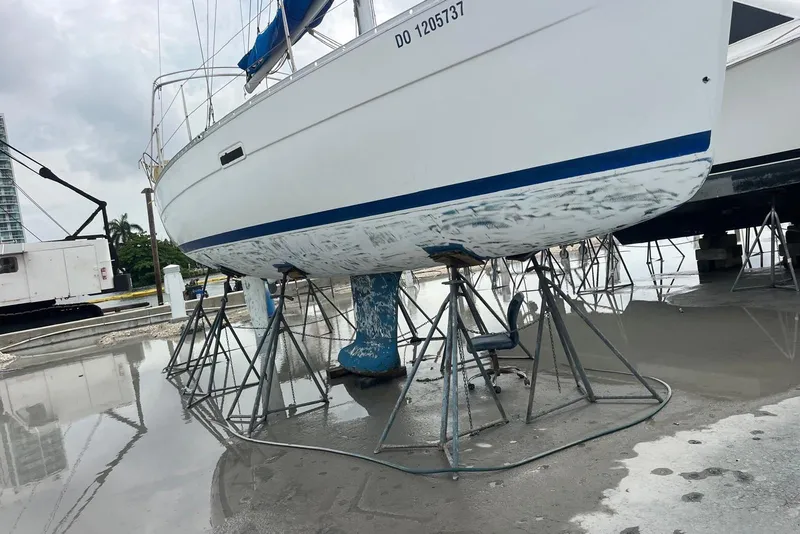 Slide: The Image of 2006 Beneteau Oceanis Clipper 323 sailboat on stands, undergoing maintenance at a marina. - 6