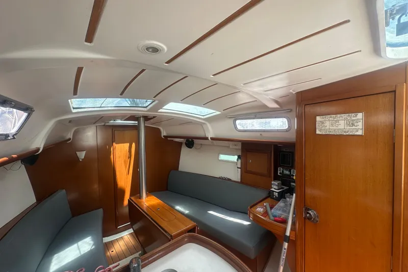 Slide: The Image of Interior of 2006 Beneteau Oceanis Clipper 323 sailboat, featuring cozy seating and wooden finishes. - 60