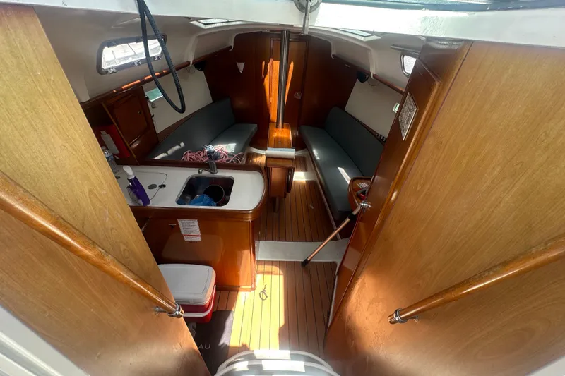 Slide: The Image of Interior of 2006 Beneteau Oceanis Clipper 323 sailboat, featuring wood finish and compact layout. - 63