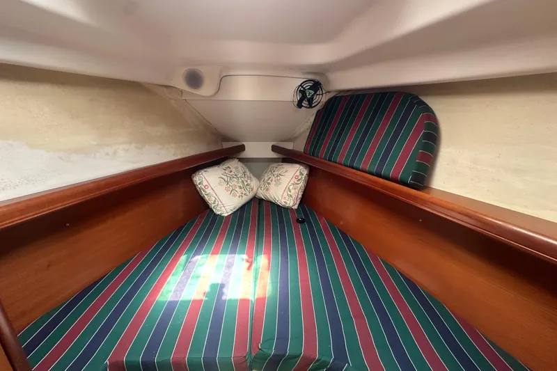Slide: The Image of Cozy cabin interior of 2006 Beneteau Oceanis Clipper 323 with striped bedding and pillows. - 67