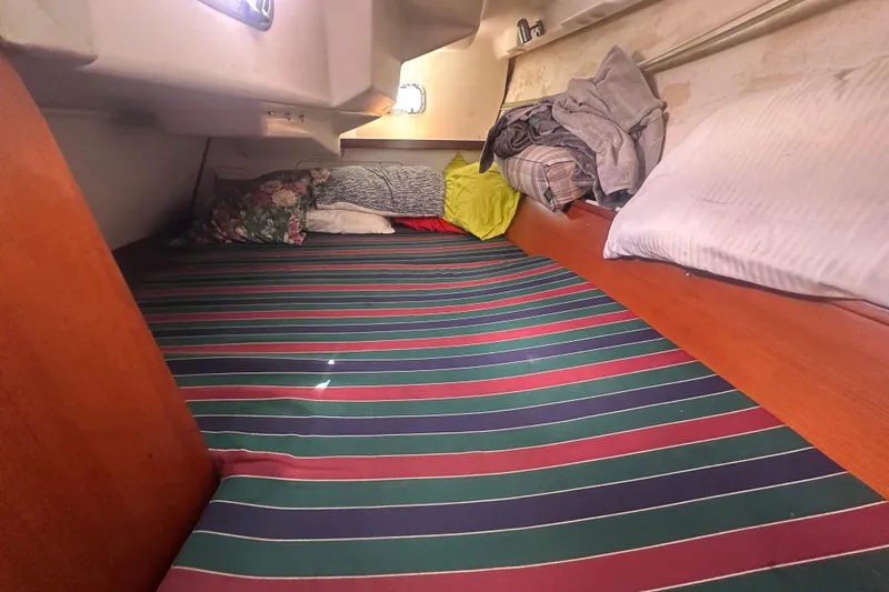 Slide: The Image of Cozy cabin interior of 2006 Beneteau Oceanis Clipper 323 with striped bedding. - 69