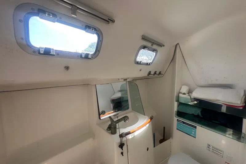 Slide: The Image of Interior of 2006 Beneteau Oceanis Clipper 323 bathroom with sink, mirror, and porthole windows. - 70
