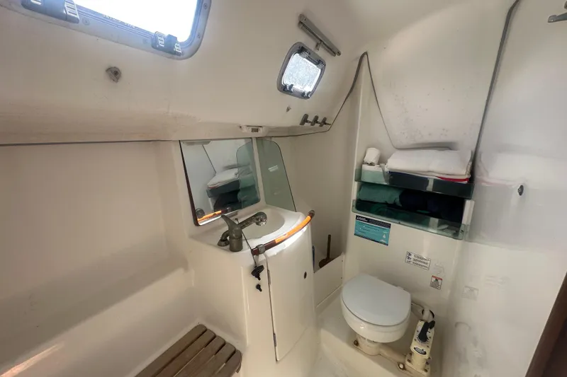 Slide: The Image of Bathroom interior of 2006 Beneteau Oceanis Clipper 323 yacht, featuring sink, toilet, and storage shelves. - 71