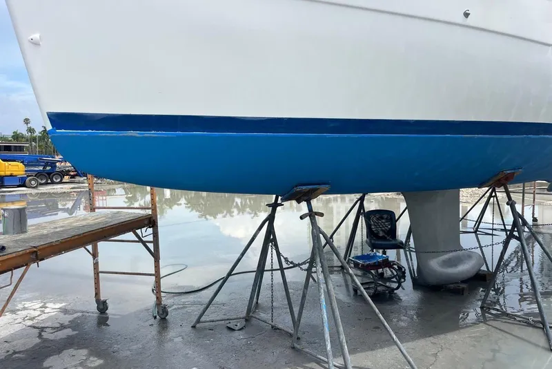 Slide: The Image of 2006 Beneteau Oceanis Clipper 323 sailboat on stands, undergoing maintenance in a shipyard. - 8