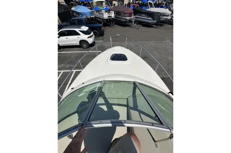 Slide: The Image of 2010 Sea Ray 240 Sundancer boat in a marina with parked cars and boats. - 11