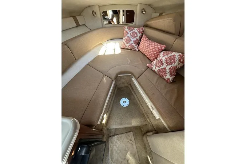 Slide: The Image of Interior of 2010 Sea Ray 240 Sundancer with beige seating and decorative pillows. - 13