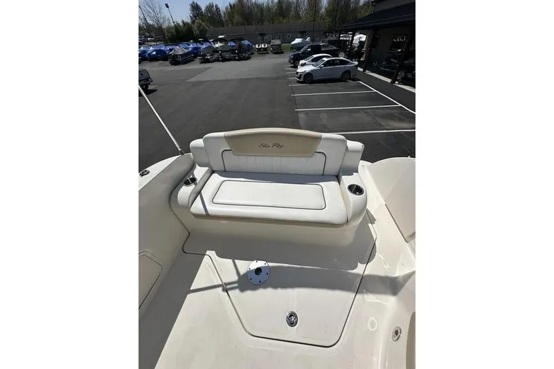 Slide: The Image of 2010 Sea Ray 240 Sundancer boat with white seating in a parking lot. - 18