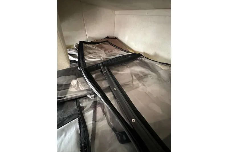 Slide: The Image of Clear plastic covers inside a 2010 Sea Ray 240 Sundancer boat cabin. - 25