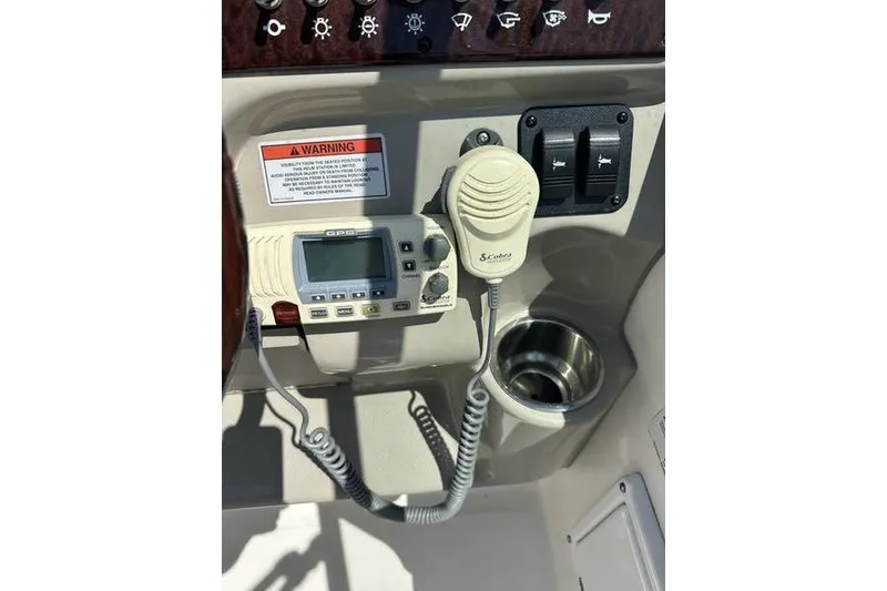 Slide: The Image of Control panel of a 2010 Sea Ray 240 Sundancer boat with radio and cup holder. - 29