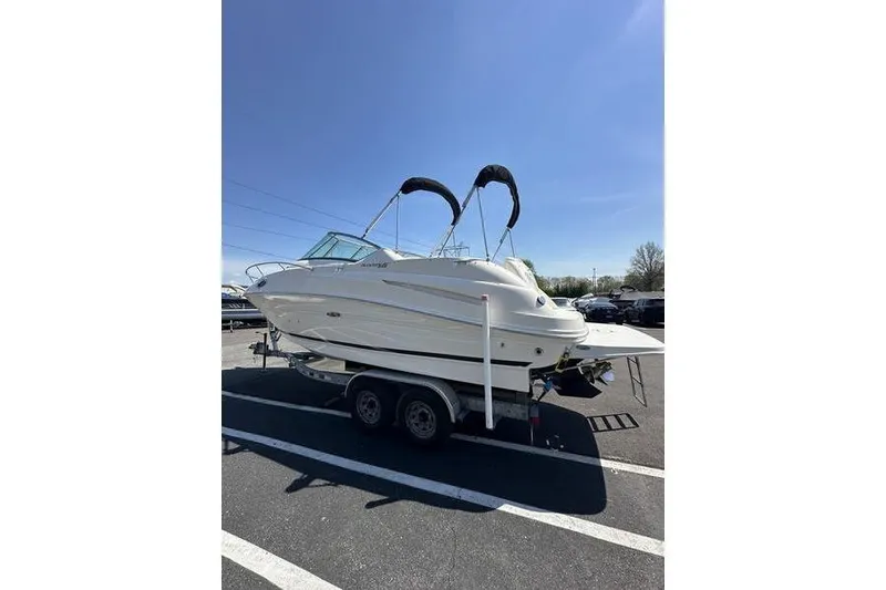 Slide: The Image of 2010 Sea Ray 240 Sundancer boat on trailer under clear blue sky. - 4