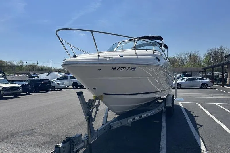 Slide: The Image of 2010 Sea Ray 240 Sundancer boat on trailer in parking lot under clear sky. - 5
