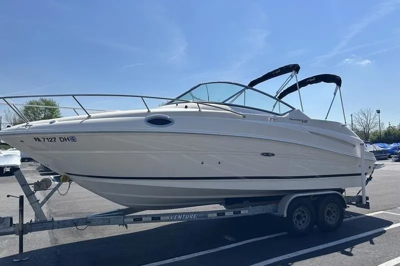 Slide: The Image of 2010 Sea Ray 240 Sundancer boat on trailer under clear blue sky. - 8