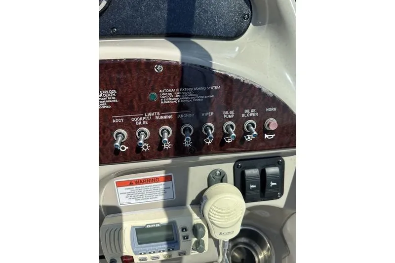 Slide: The Image of Control panel of a 2010 Sea Ray 240 Sundancer boat with various switches. - 9