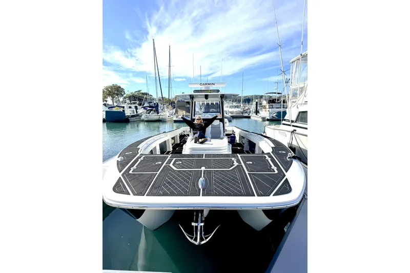 The Image of 2021 Invincible 35 Catamaran docked at marina with person onboard, clear sky background. - 0