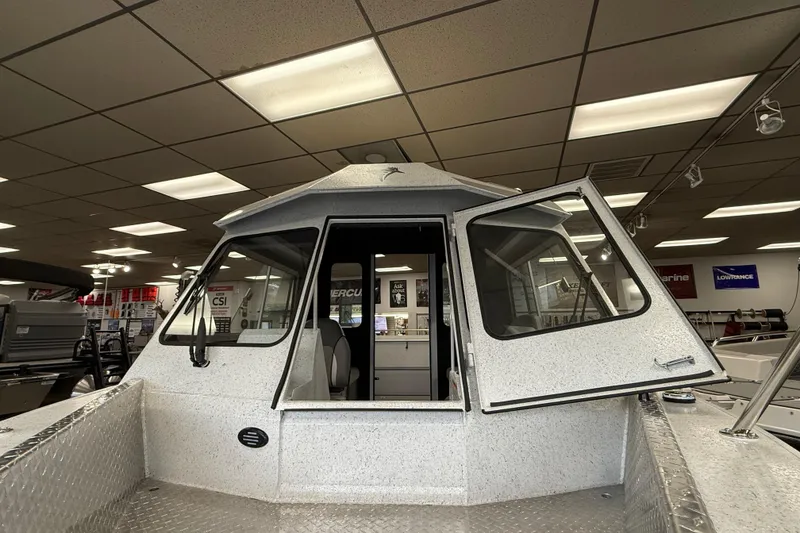 Slide: The Image of KingFisher 2025 Escape HT boat in showroom, featuring open cabin doors and modern design. - 3