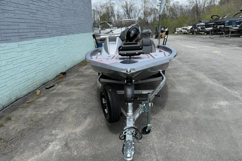 Slide: The Image of 2026 Xpress H18C Crappie boat on trailer, parked outdoors near a blue wall. - 3