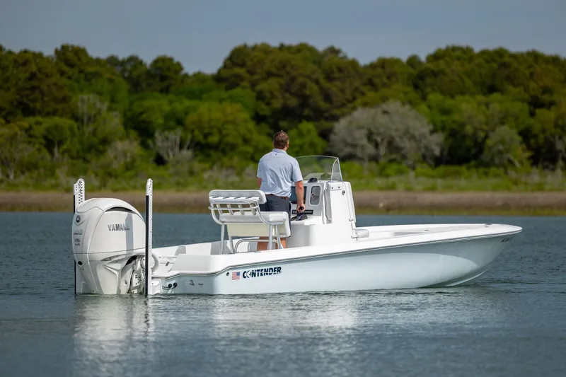 Slide: The Image of 2024 Contender 23 Bay boat on water, featuring Yamaha engine, with lush green background. - 13