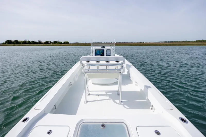 Slide: The Image of 2024 Contender 23 Bay boat on calm water, showcasing spacious deck and sleek design. - 14