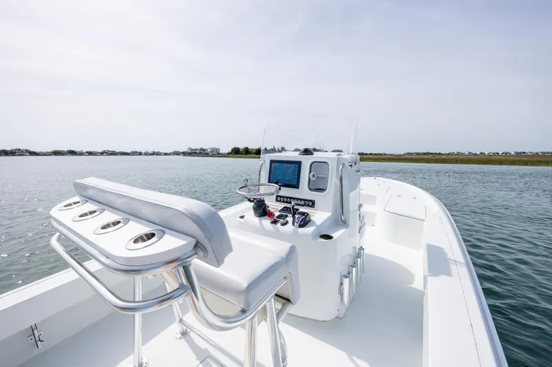 Slide: The Image of 2024 Contender 23 Bay boat interior with console and seating on calm water. - 16