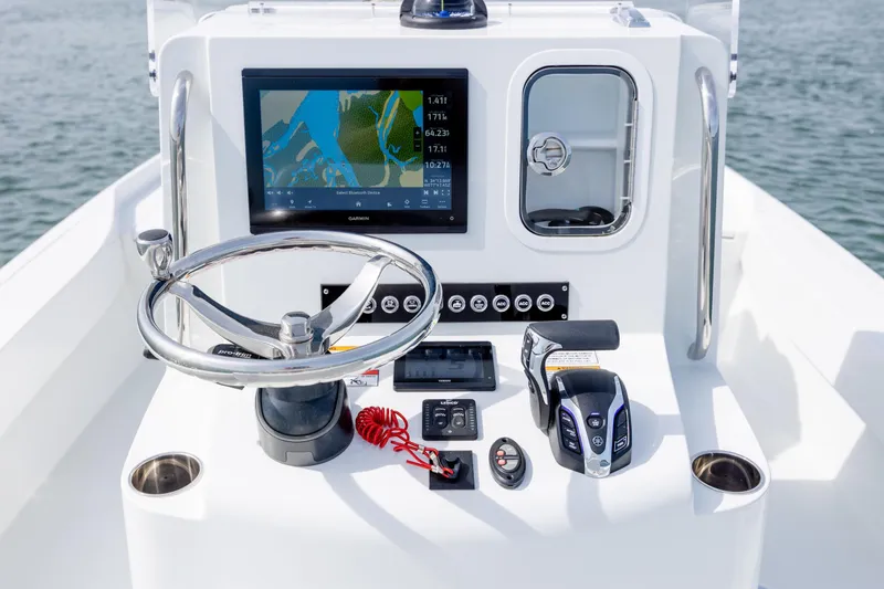 Slide: The Image of 2024 Contender 23 Bay boat console with steering wheel, navigation screen, and controls. - 17