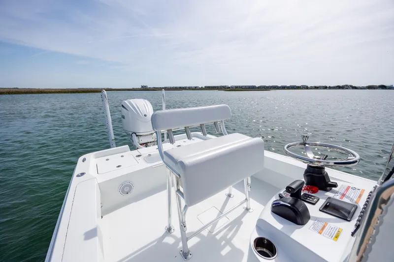 Slide: The Image of 2024 Contender 23 Bay boat on calm water, featuring sleek design and modern controls. - 23