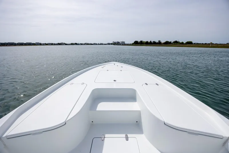 Slide: The Image of 2024 Contender 23 Bay boat on calm water, showcasing sleek deck design. - 26