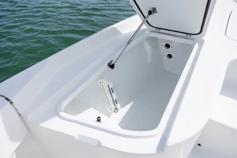 Slide: The Image of Open storage compartment on 2024 Contender 23 Bay boat, with hydraulic lift, near water. - 30