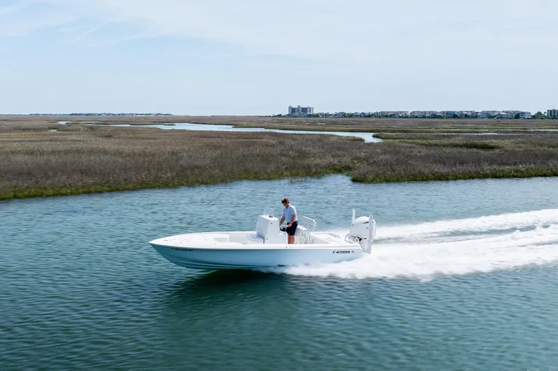 Slide: The Image of 2024 Contender 23 Bay boat cruising on a scenic waterway. - 37