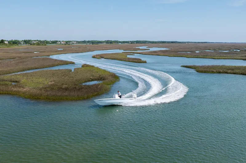 Slide: The Image of 2024 Contender 23 Bay boat navigating winding waterway with lush marshland. - 41