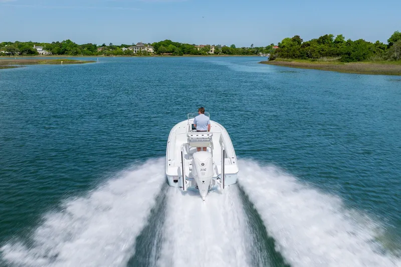 Slide: The Image of 2024 Contender 23 Bay boat cruising on a scenic waterway. - 42