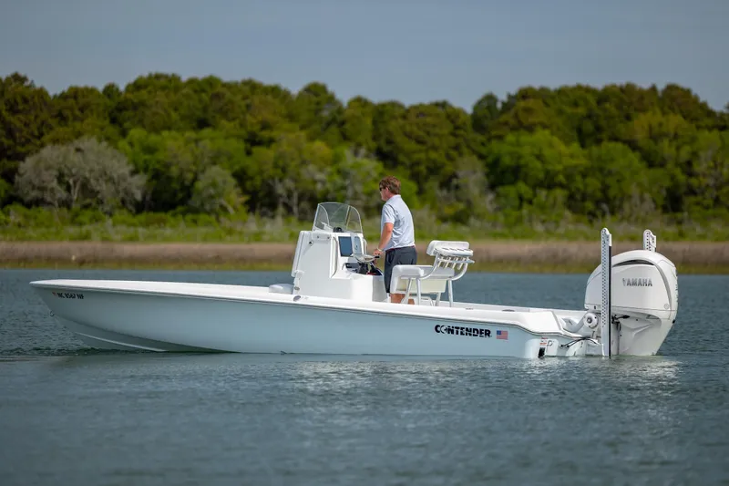 Slide: The Image of 2024 Contender 23 Bay boat on calm water, featuring Yamaha outboard motor. - 9