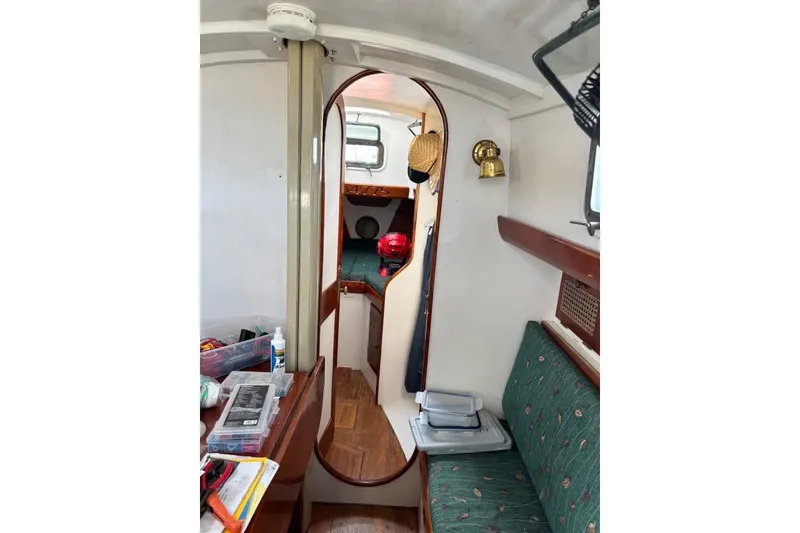 The Image of Interior of 1998 Peter Scott Chuck Paine 30 sailboat with cozy seating and wooden accents. - 0