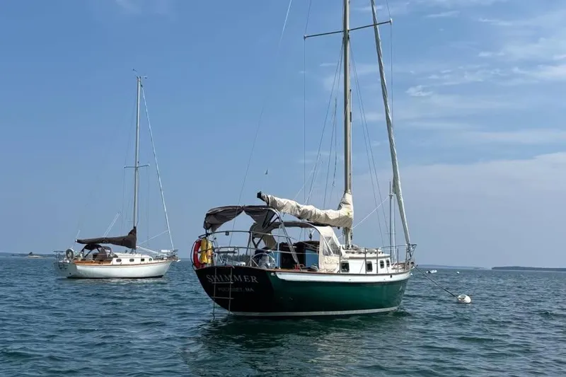 Slide: The Image of Sailboat "Peter Scott Chuck Paine 30" on serene water, surrounded by forested shoreline. - 4