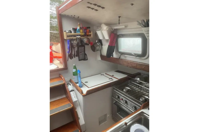 Slide: The Image of Cozy interior of 1998 Peter Scott Chuck Paine 30 sailboat with green seating and wooden accents. - 7