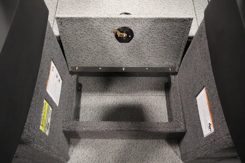 Slide: The Image of Interior storage compartment of 2026 Crestliner 2050 Authority boat, featuring carpeted finish and safety labels. - 29